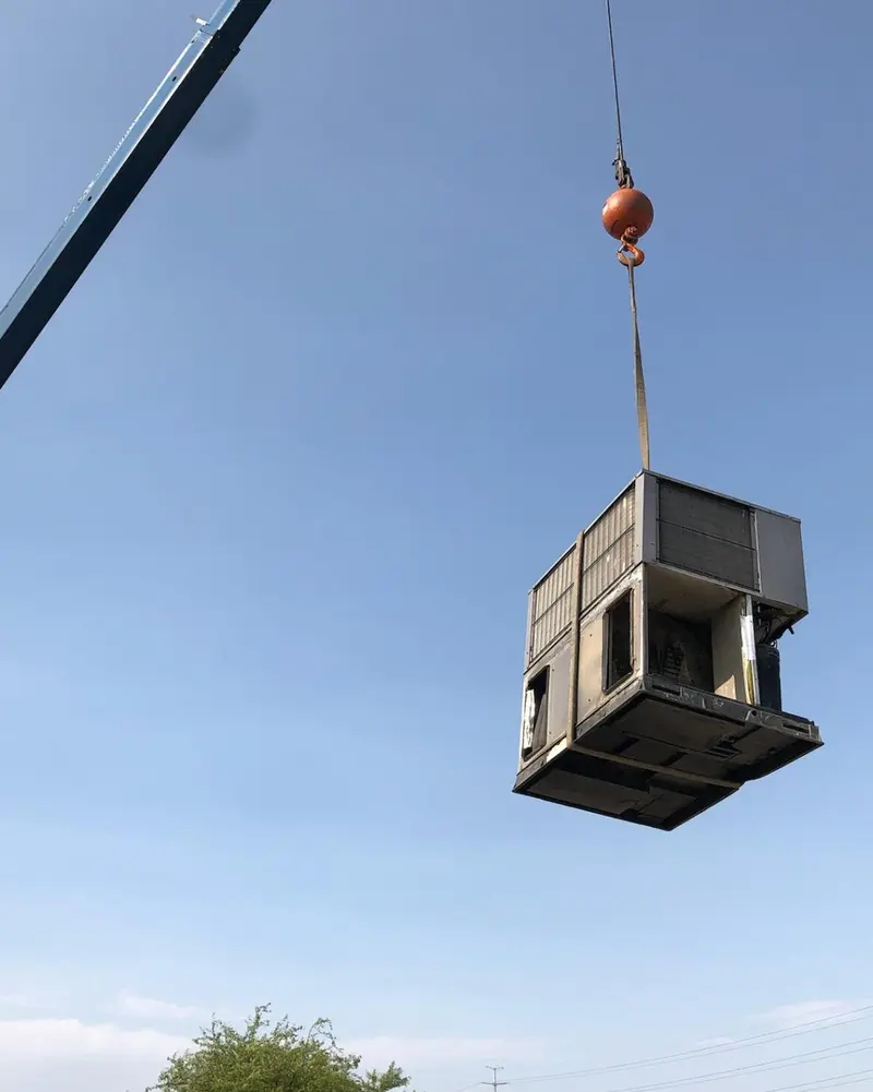 Crane lifting commercial HVAC unit for Las Vegas rooftop installation