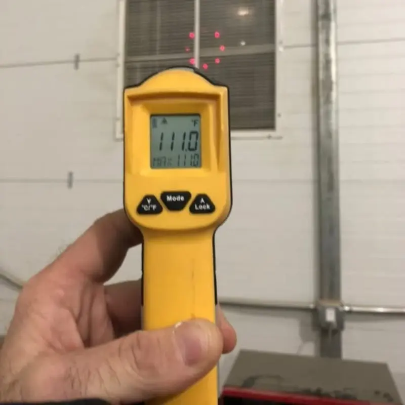 Fluke temperature gun reading 111°F verifying commercial HVAC performance