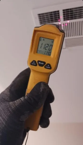 Infrared thermometer checking vent temperature during a North Las Vegas AC diagnostic