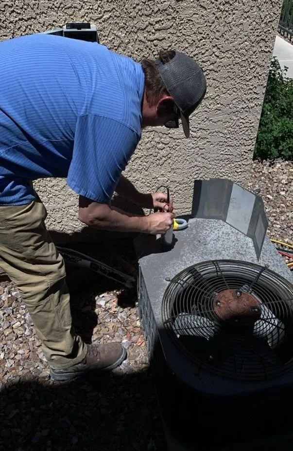 HVAC technician servicing air conditioner in Las Vegas home