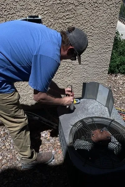 HVAC technician performing AC tune-up maintenance